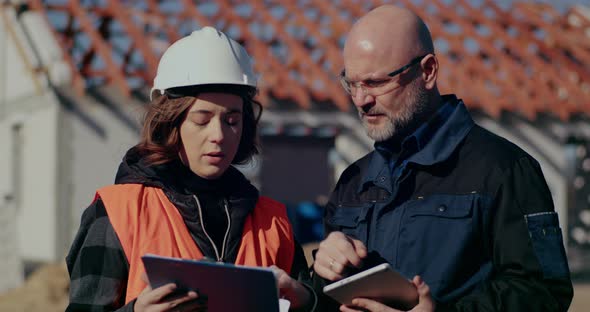 Concentrated Engineers Discussing Examining and Developing at Construction Site