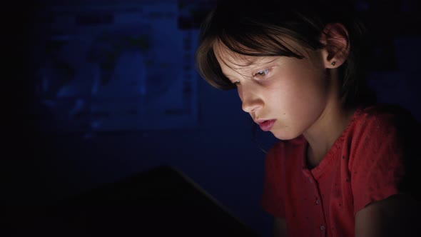 Girl Playing on Tablet in the Dark