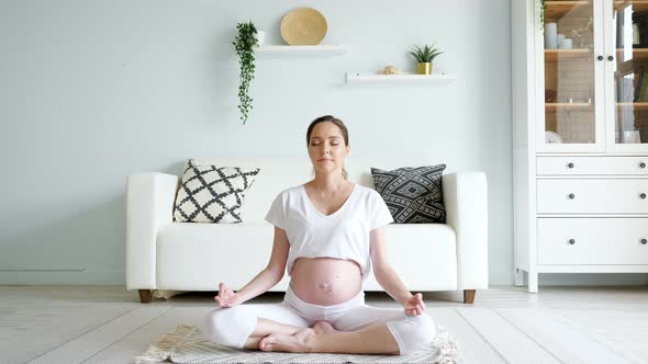 Tranquil Pregnant Woman Meditates in Lotus Pose at Home