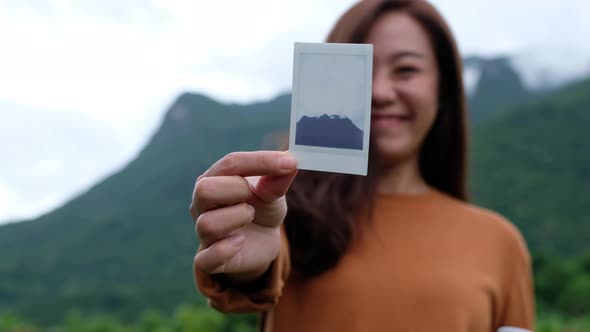 A female traveler showing a photo of a beautiful greenery mountains