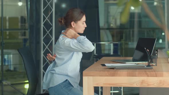 Woman Work at a Table With a Laptop Suddenly Feeling Pain in Neck and Back