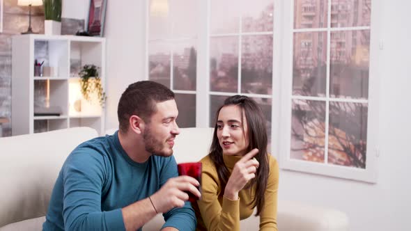 Man Sitting on Sofa Drinking Soda While Watching a Movie