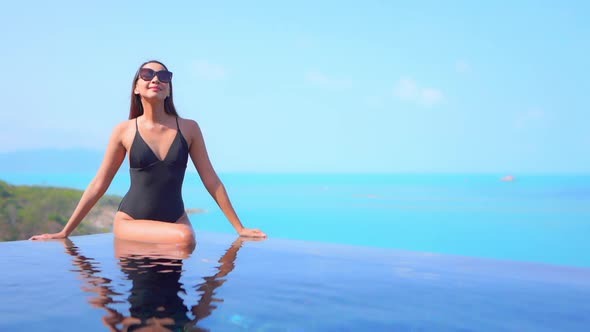 Young asian woman enjoy around outdoor swimming pool for leisure