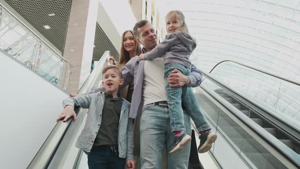 A Large Family Rides Down the Escalator