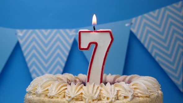 Happy birthday. 7 year old, cupcake, birthday cake with candles on a blue background.close-up