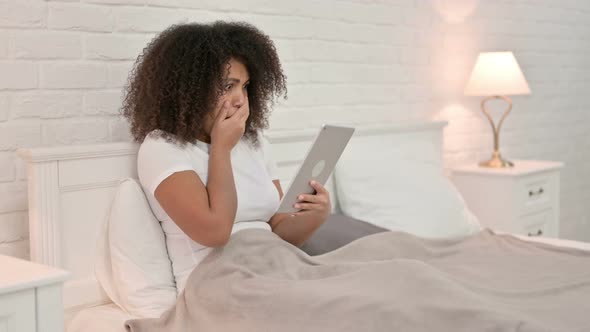 Online Video Chat on Tablet By Young African Woman in Bed