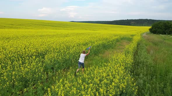 The Guy Runs Through the Flower Field Holding a Plane