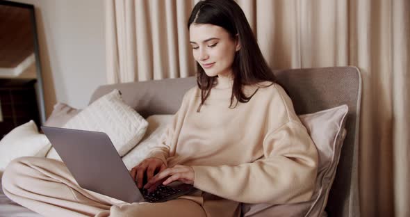 Happy Pretty Female Working From Home on Key Laptop Computer From Bedroom
