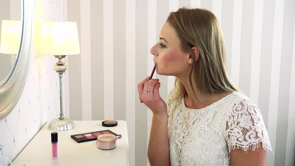 A Young Attractive Woman Makes Herself Up in Front of a Mirror