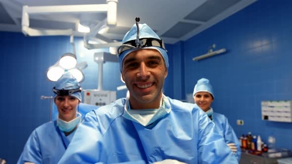 Portrait of surgeon and nurses standing in operation room