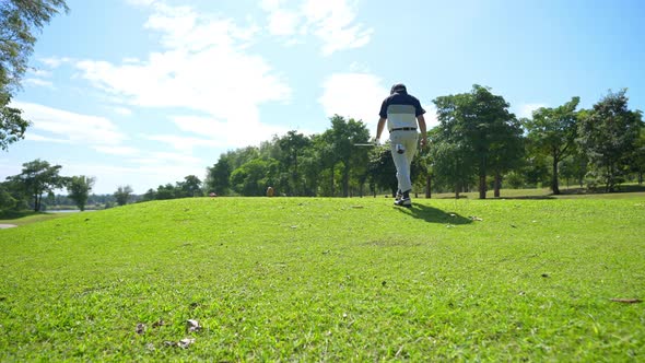 4K Portrait of Asian man golfer golfing on golf course at country club at summer sunny day.