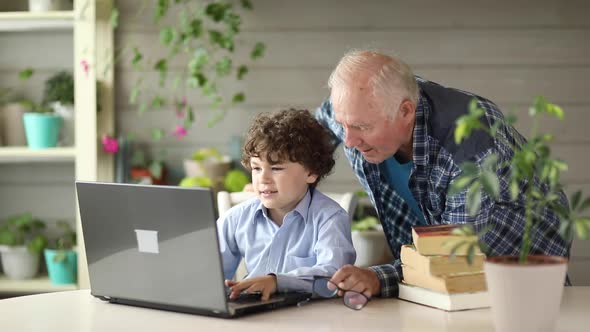 Grandfather and grandson study on the computer at home ,back to school