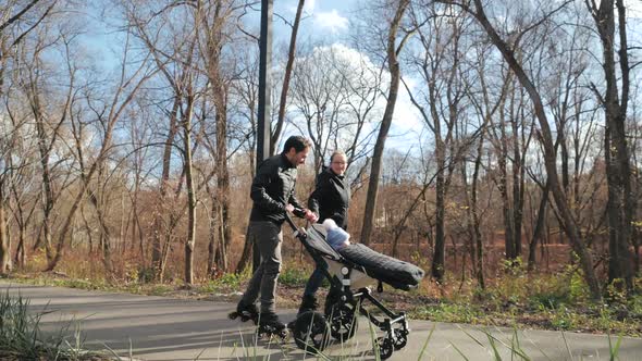 Family Performance in the Autumn Park, Roller Blades and Stroller. Dad Catches Up with Mom and Gives