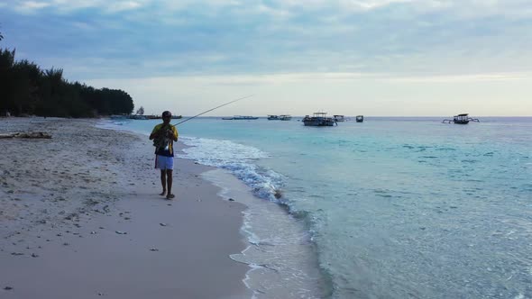 Guy happy and fishing on relaxing sea view beach wildlife by blue green sea with clean sand backgrou