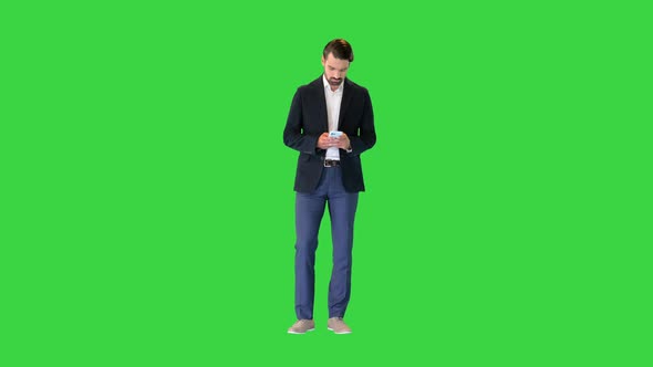 Handsome Happy Business Man Texting on Smartphone on a Green Screen Chroma Key