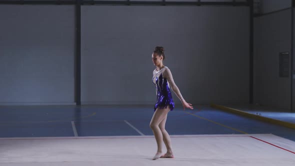 Teenage female gymnast performing at sports hall