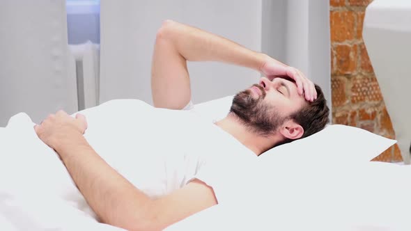 Uncomfortable Beard Man Sleeping in Bed at Night Restlessness