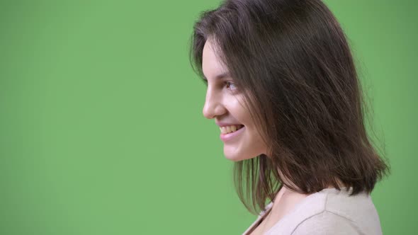 Profile View of Young Happy Beautiful Woman Against Green Background