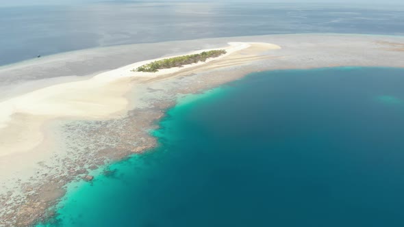 Aerial: Flying over idyllic atoll, travel destination Wakatobi National Park Ind