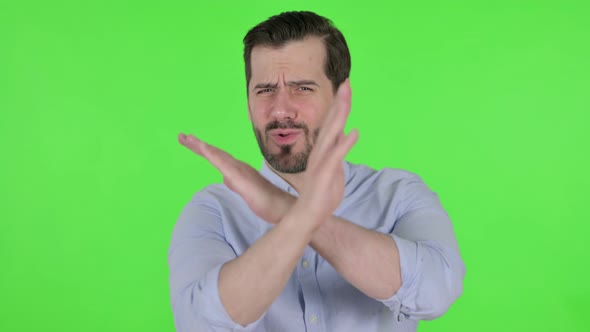 Portrait of Man Showing No Sign By Arm Gesture Green Screen