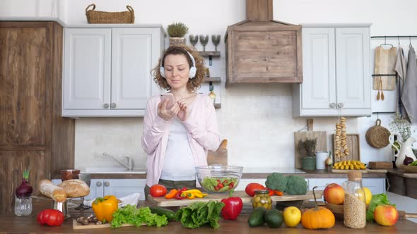 Pregnant Woman Cooking Healthy Food On Kitchen And Using Smartphone