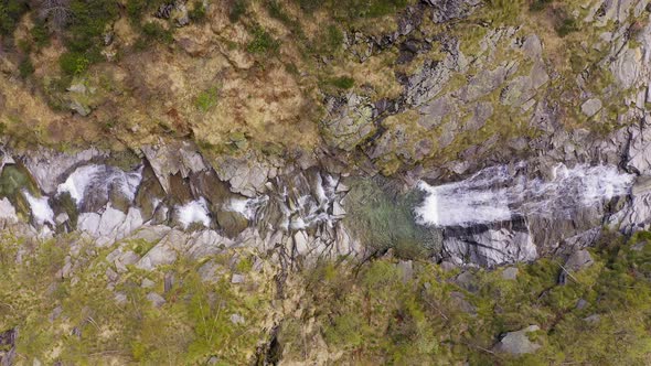 Aerial View of Waterfall Flowing Trough Rocks of Mountain