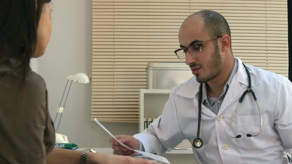 Arabian Male Doctor Explaining Cardiogram To Female Patient