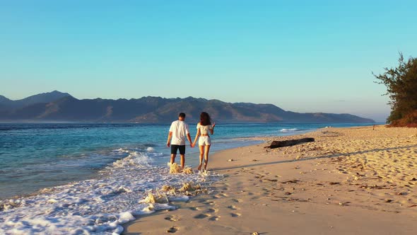 Fun Man and Woman on Romantic Honeymoon Enjoy Luxury on Beach on Summer White Sandy