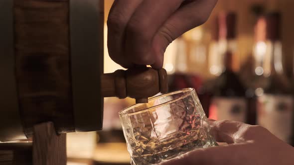 In Wine or Cognac Cellar Close Up View of Whiskey is Poured From Barrel Into Glass