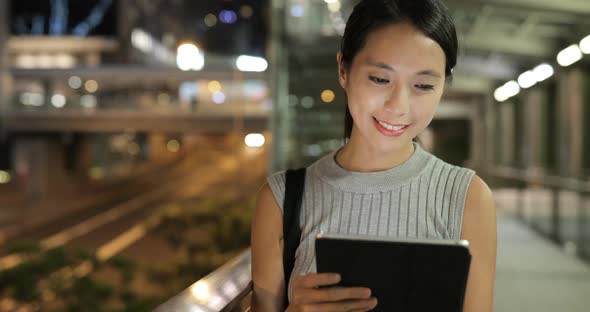 Woman using tablet computer at night