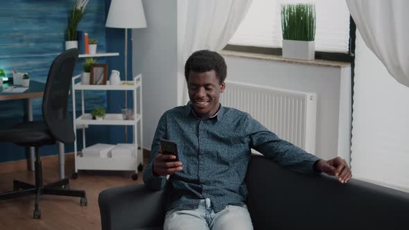 African American Guy Greeting Colleagues or Family While Talking on Online Video Conference Call