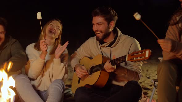 Friends Roasting Marshmallow and Playing Guitar