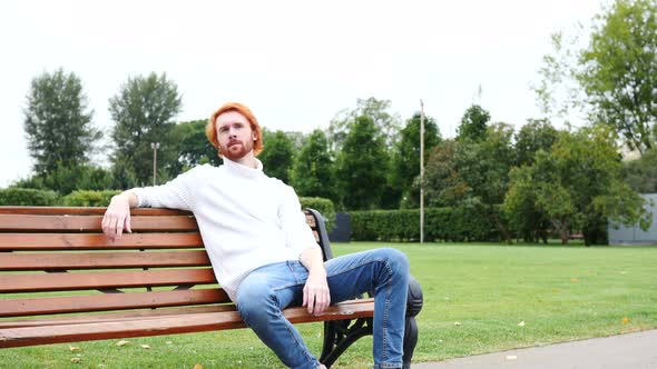 Thumbs Up by Man Sitting on Bench in Park, Red Hairs and Beard