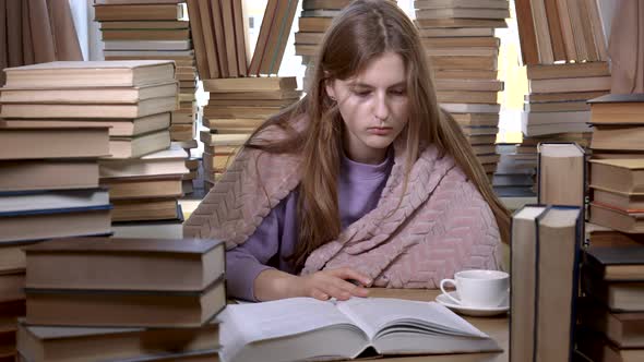 A Girl Reads a Book in the Library