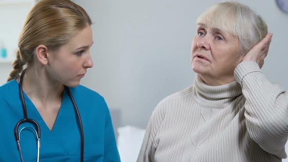 Young Doctor Taking Notes, Elderly Lady Telling Medical Worker Disease Symptoms