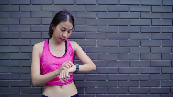 Young Asian Athlete women legs warming and stretching her arms to ready for running on street