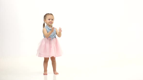 Child Is Standing and Clapping Wannabes and Twisting His Arms Around. White Background