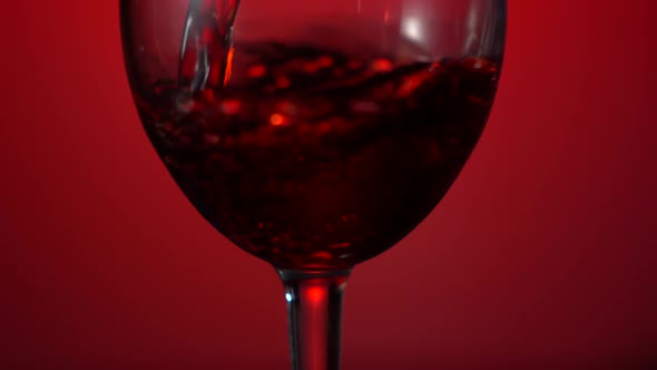 Red Wine Pouring From Bottle to Clear Glass