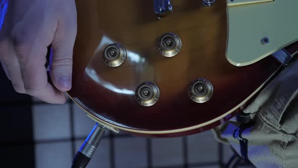 Hand tuning volume and tone guitar knobs.