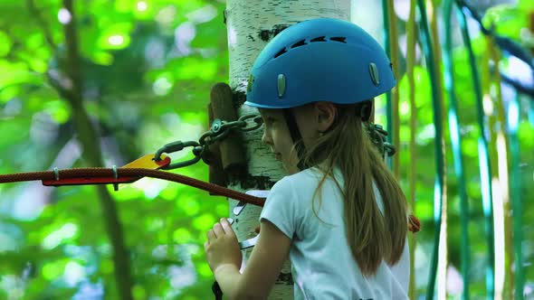 Rope Adventure - a Little Girl Walking on a Rope Bridge with Insurance Belt