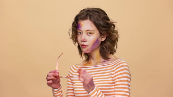 Half Turn Portrait of Modern Female Designer with Colorful Drawing on Face Wearing Round Eyeglasses