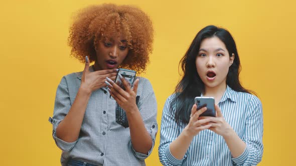 Young Black and Asian Women Looking at Social Media Post with Surprised Face