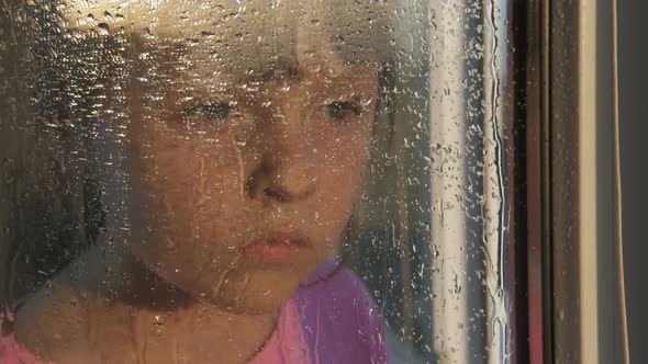 Sad child by the window. 