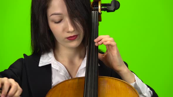 Woman Pins the Cello with Her Fingers. Green Screen. Close Up