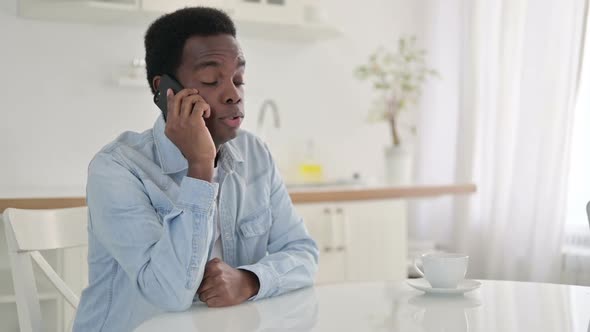 Cheerful African Man Talking on Smart Phone at Home