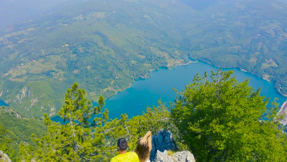 Aerial View on Couple Standing Against Amazing Nature View on Mountain Lake in on the Border of