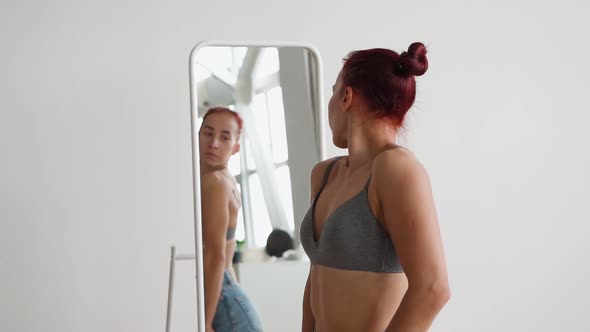 Attractive Happy Woman Looks in Mirror Choosing What Wear on White Background