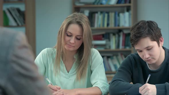 Group of Young Students Writing Notes in the Classroom