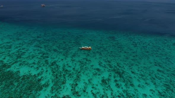 Drone Over Turquoise Sea With Moored Boat