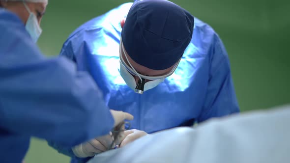 Expert Surgeon Operating Patient on Surgery Bed with Nurse Cleaning Dissection in Slow Motion